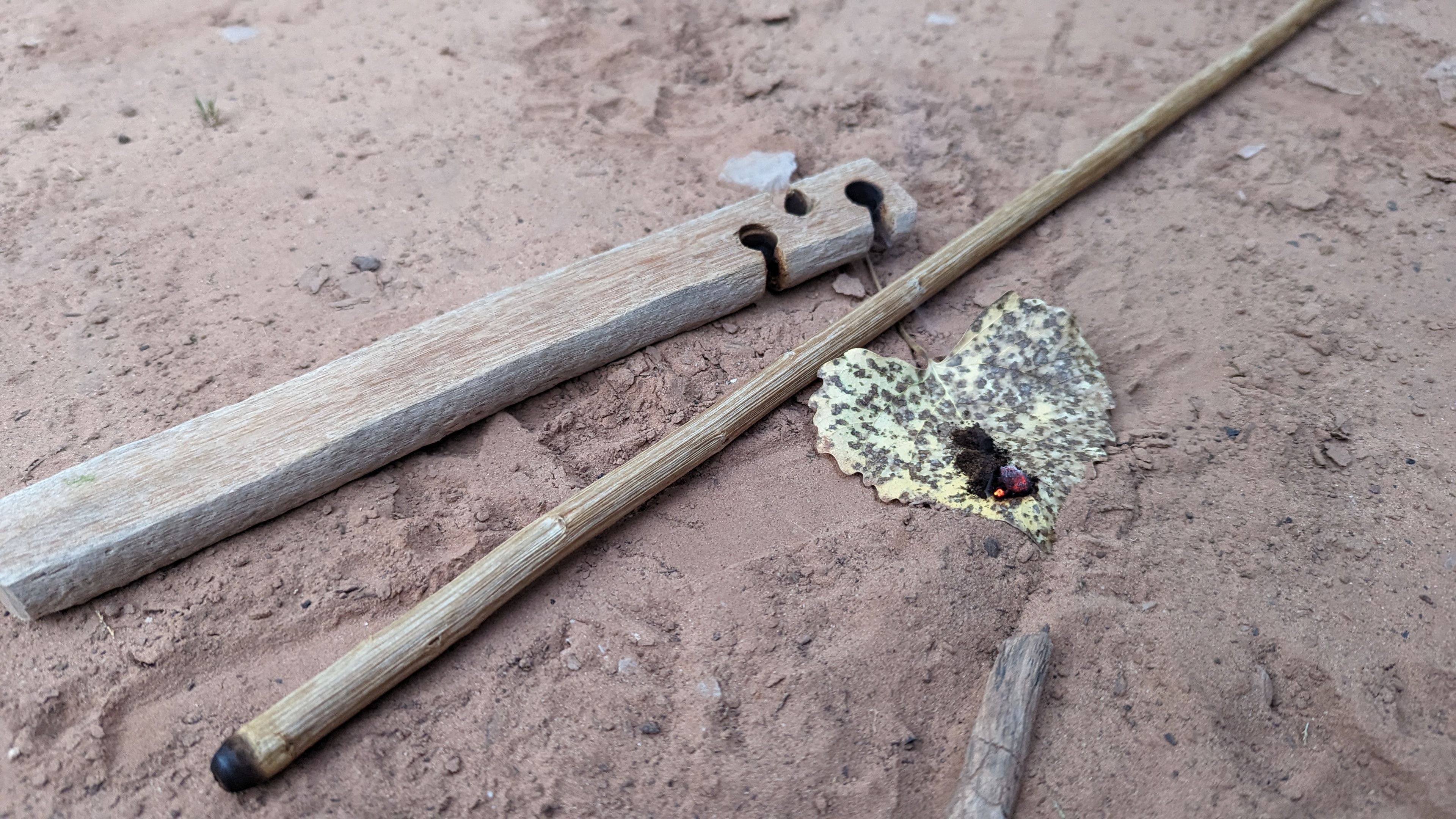 Primitive survival tools and fire kit laid out in the field
