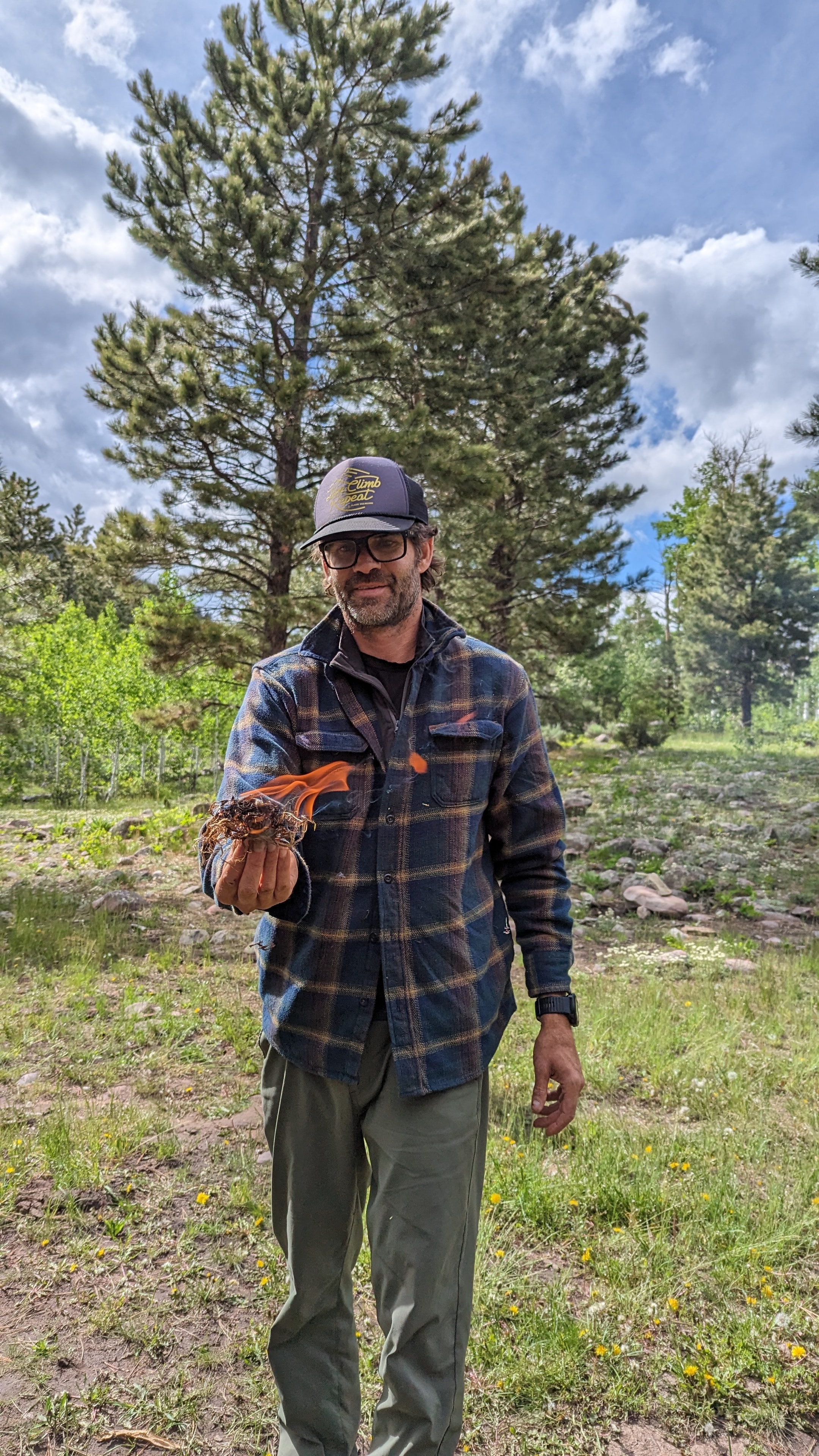 Instructor holding a newt in a forest clearing